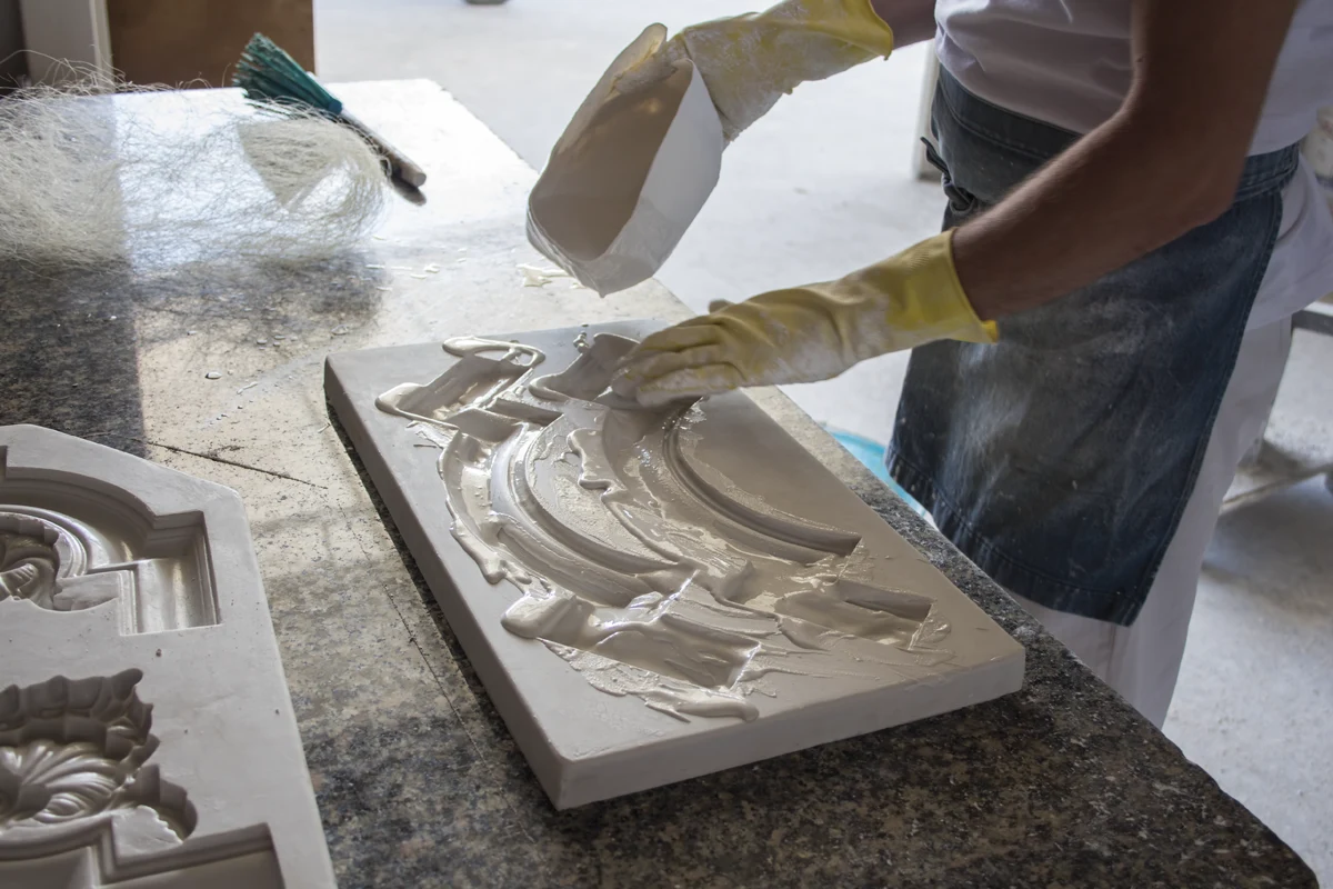 Colata del gesso nello stampo di una decorazione nel laboratorio