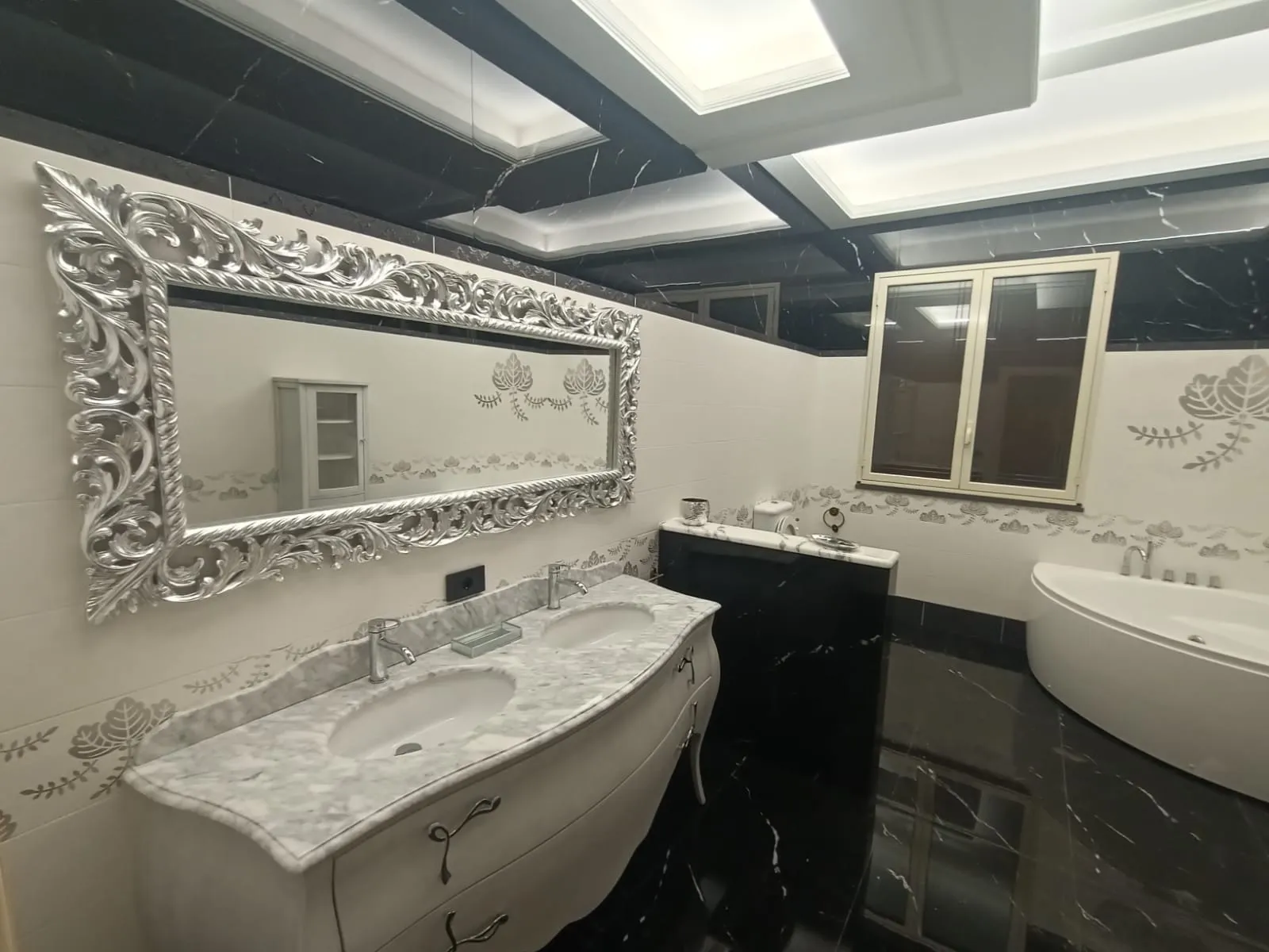 Bagno con controsoffitto a cassettoni in gesso retroilluminato e specchio con cornice argentata